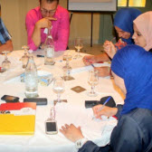 Teilnehmer am Tisch bei der gemeinsamen Projektarbeit.